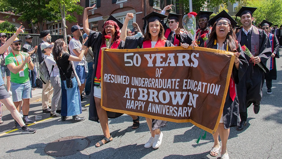 RUE alumni cheering and carrying the banner during Procession